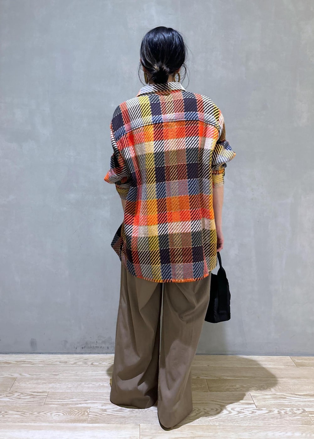 ブラック系のハンドバッグ、グリーン系のスラックスを着用したレディースの秋コーディネートの5枚目の写真