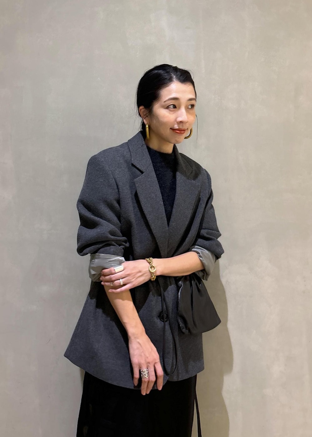 グレー系のニット/セーター、グレー系のテーラードジャケット、ブラック系のその他パンツを着用したレディースの秋コーディネートの6枚目の写真