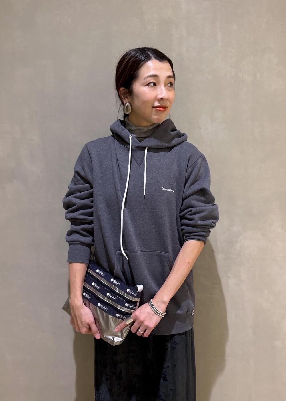 グレー系のスニーカー、ブラック系のスカート、グレー系のパーカーを着用したレディースの冬コーディネートの10枚目の写真