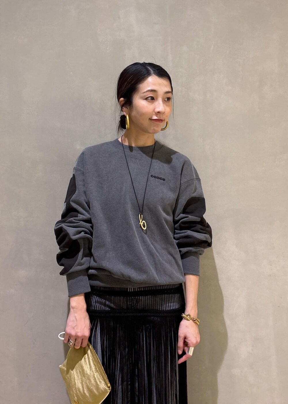 ブラック系のデニムパンツ、ブラック系のスカート、ベージュ系のポーチを着用したレディースの冬コーディネートの8枚目の写真