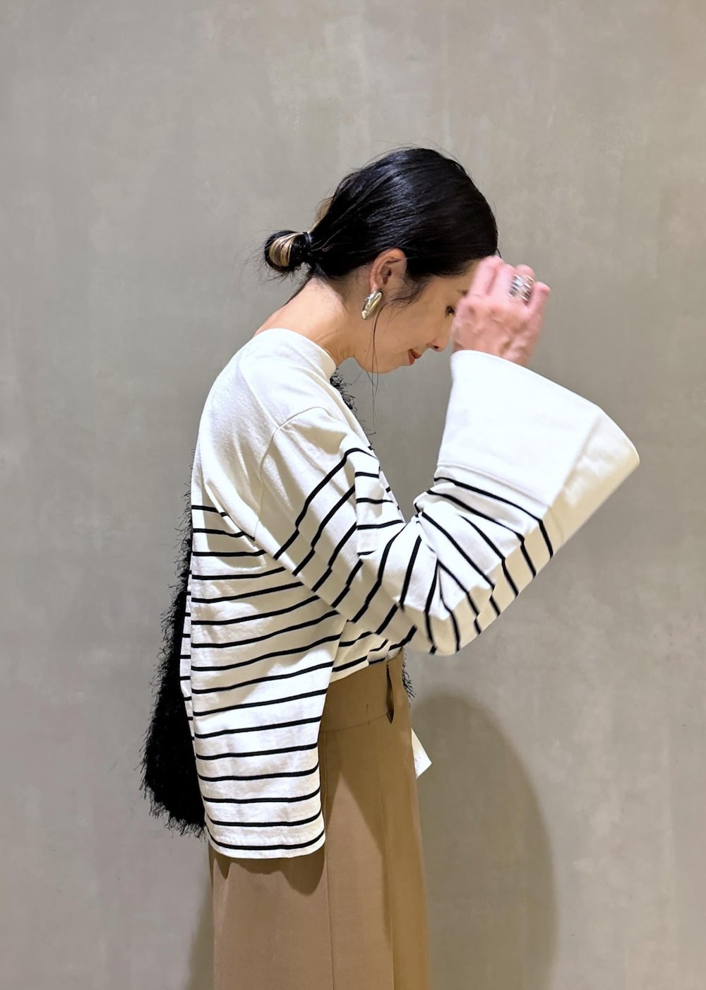ベージュ系のスカート、ホワイト系のTシャツ/カットソー、ブラック系のハンドバッグを着用したレディースの夏コーディネートの8枚目の写真