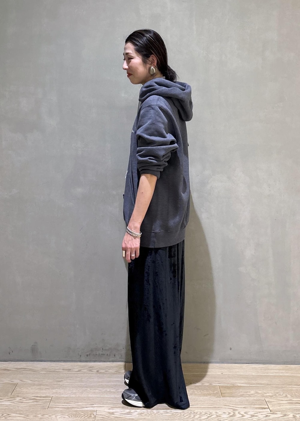 グレー系のスニーカー、ブラック系のスカート、グレー系のパーカーを着用したレディースの冬コーディネートの3枚目の写真