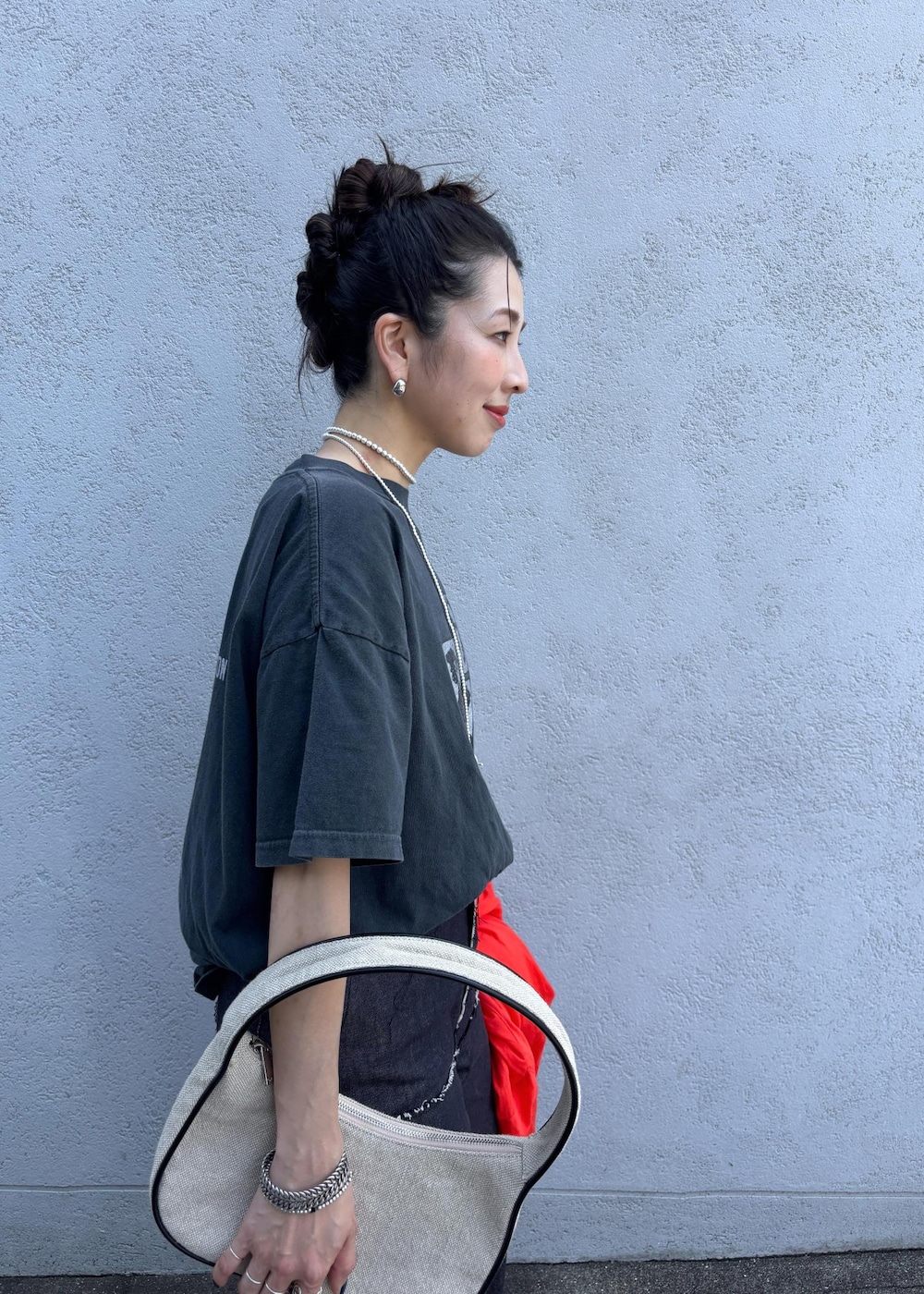レッド系のシャツ/ブラウス、ブルー系のデニムパンツ、ホワイト系のハンドバッグを着用したレディースの夏コーディネートの6枚目の写真