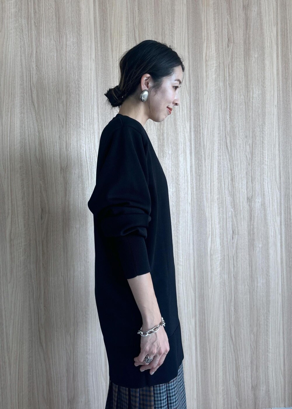 グレー系のスカート、ブラック系のブーツ、ブラック系のニット/セーターを着用したレディースの秋コーディネートの9枚目の写真