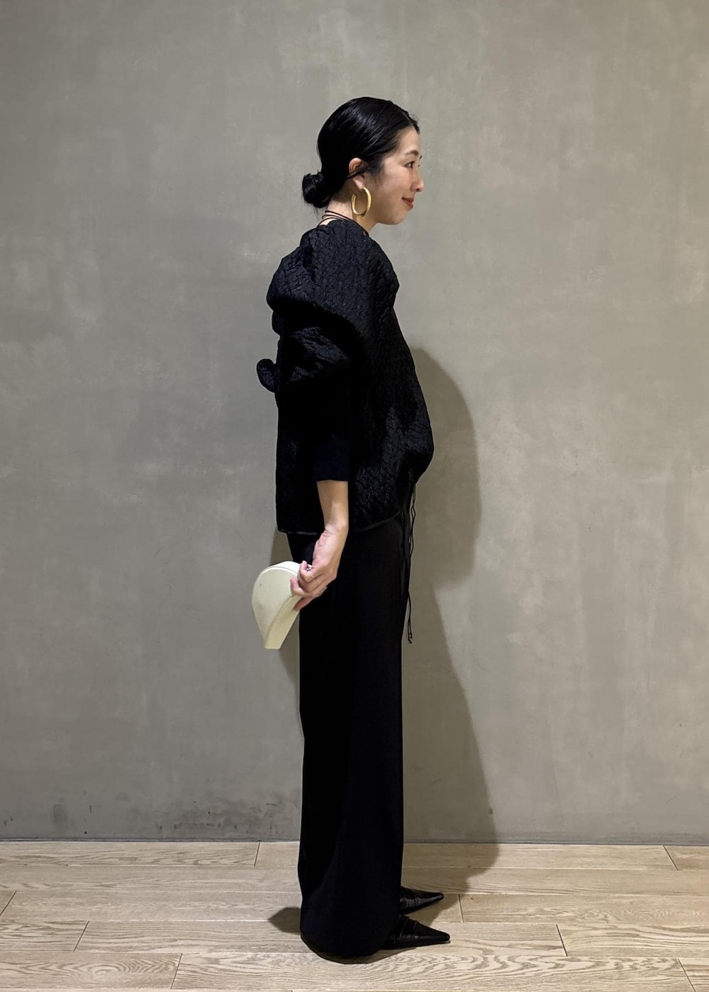 ブラック系のサンダル、ブラック系のスラックス、ブラック系のTシャツ/カットソーを着用したレディースの冬コーディネートの2枚目の写真