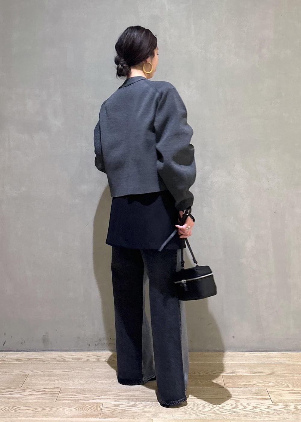 ブラック系のデニムパンツ、ブラック系のスカート、ブラック系のショルダーバッグを着用したレディースの冬コーディネートの6枚目の写真