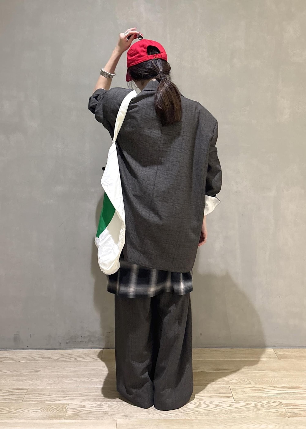 ブラック系のシャツ/ブラウス、グリーン系のトートバッグ、ブラック系のキャップを着用したレディースの秋コーディネートの3枚目の写真