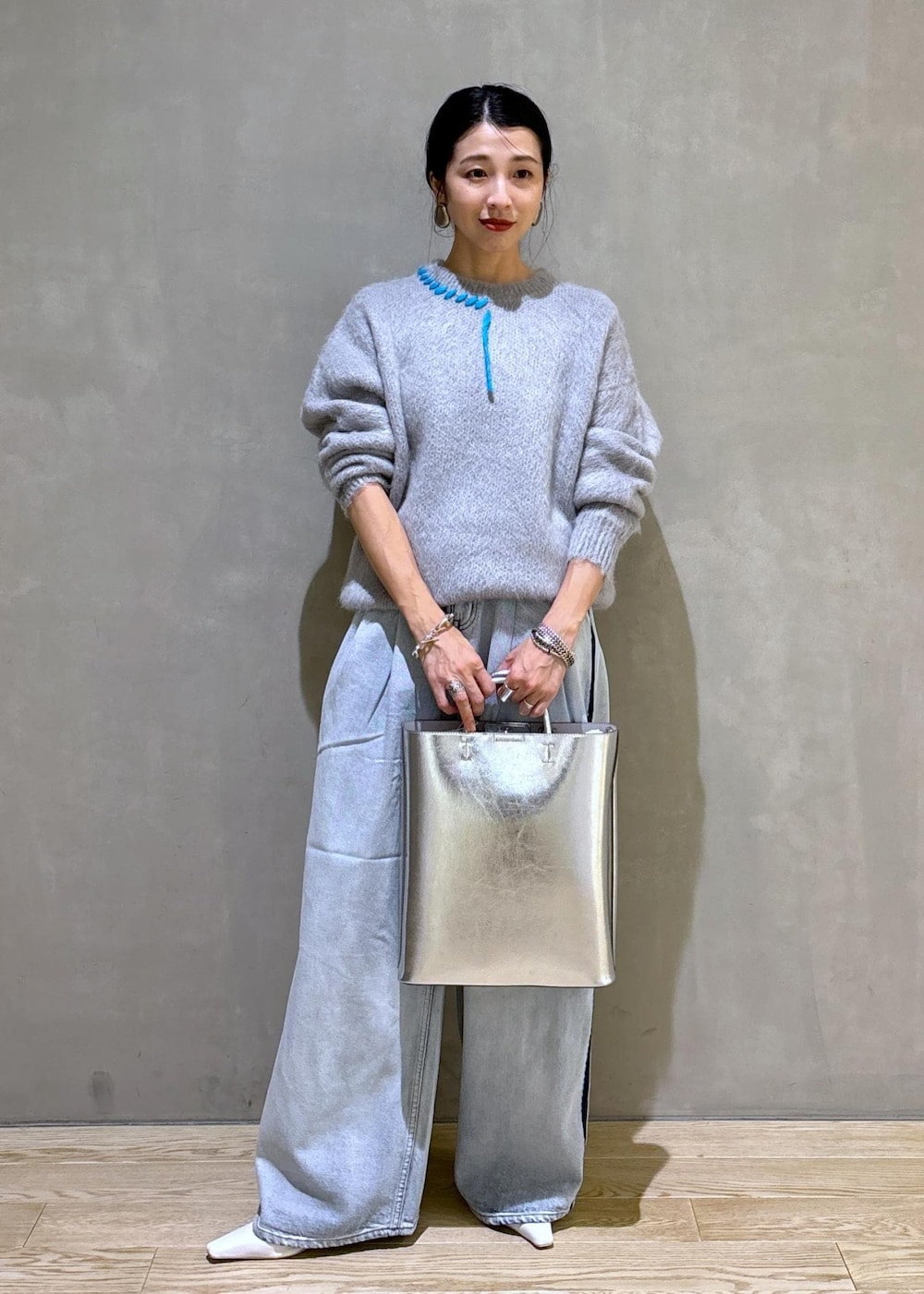 ホワイト系のパンプス、シルバー系のトートバッグ、ブルー系のその他パンツを着用したレディースの秋コーディネートの2枚目の写真