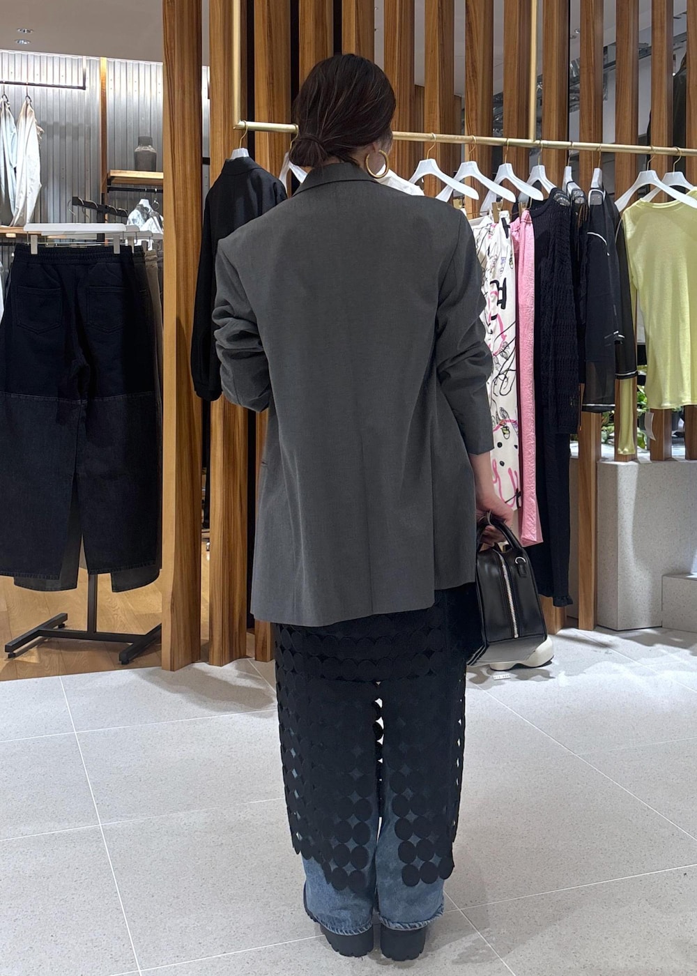 ブルー系のデニムパンツ、グレー系のテーラードジャケット、ブラック系のローファーを着用したレディースの春コーディネートの3枚目の写真