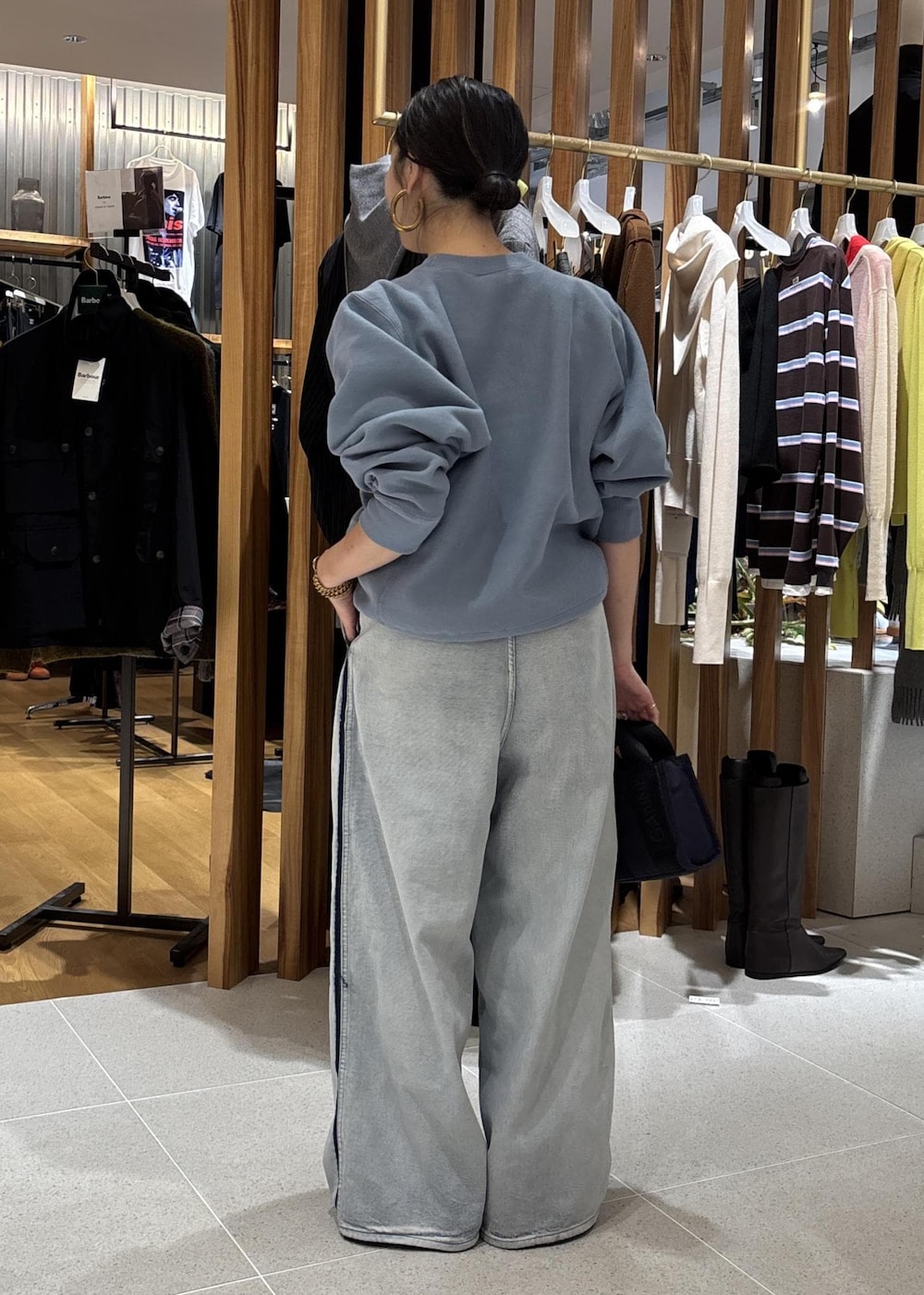 ブルー系のデニムパンツ、ブルー系のショルダーバッグ、ブルー系のスウェットを着用したレディースの秋コーディネートの6枚目の写真