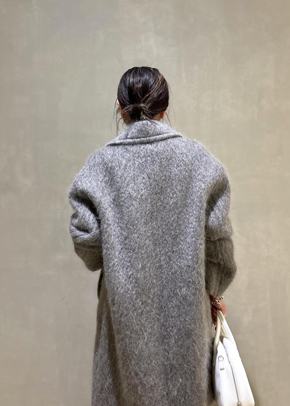 ホワイト系のボストンバッグ、グレー系のカーディガン/ボレロ、グレー系のチェスターコートを着用したレディースの秋コーディネートの10枚目の写真