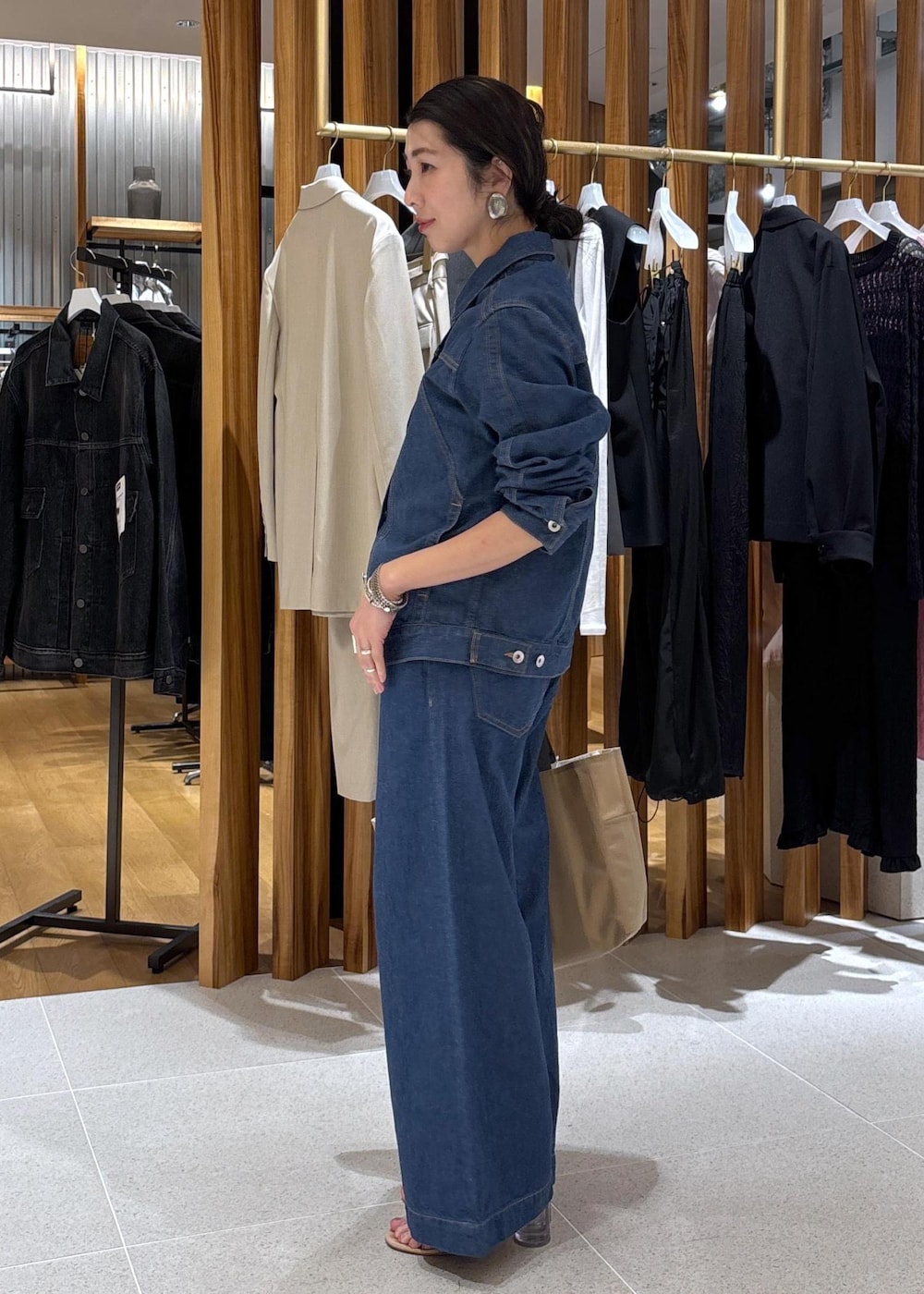 ベージュ系のハンドバッグ、ブルー系のTシャツ/カットソー、ブルー系のブルゾンを着用したレディースの冬コーディネートの4枚目の写真