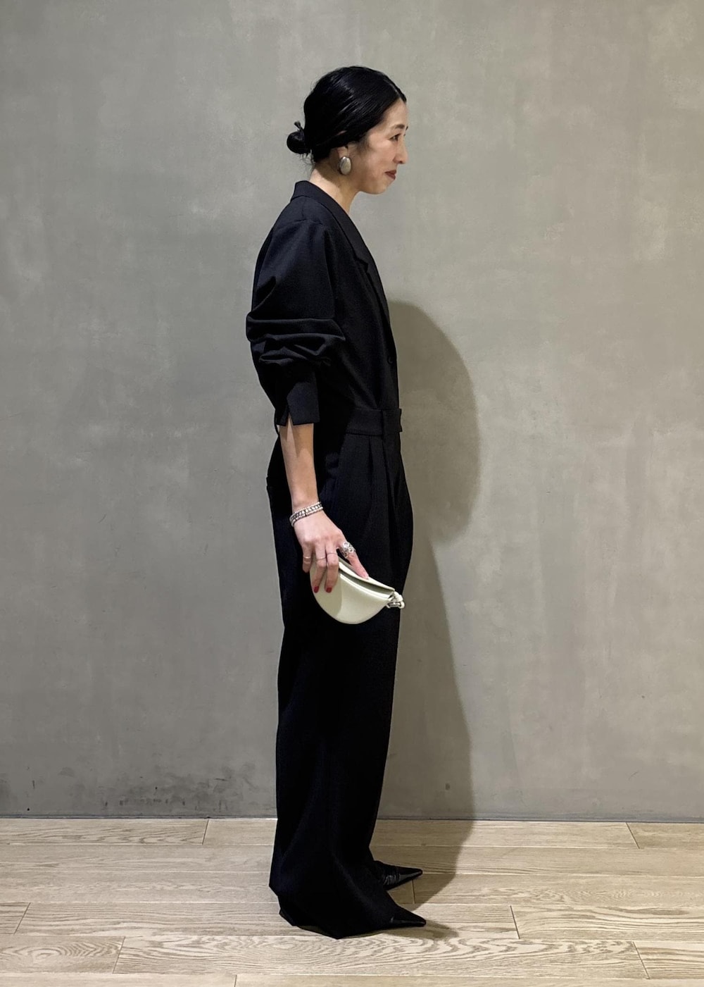 ブラック系のサンダル、グレー系のつなぎ/オールインワン、ホワイト系のキーホルダーを着用したレディースの秋コーディネートの3枚目の写真