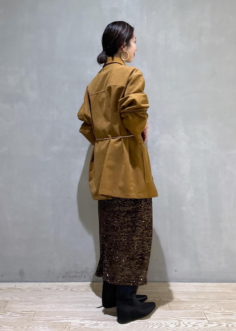 ブラック系のブーツ、ブラック系のスカート、イエロー系のブルゾンを着用したレディースの冬コーディネートの4枚目の写真