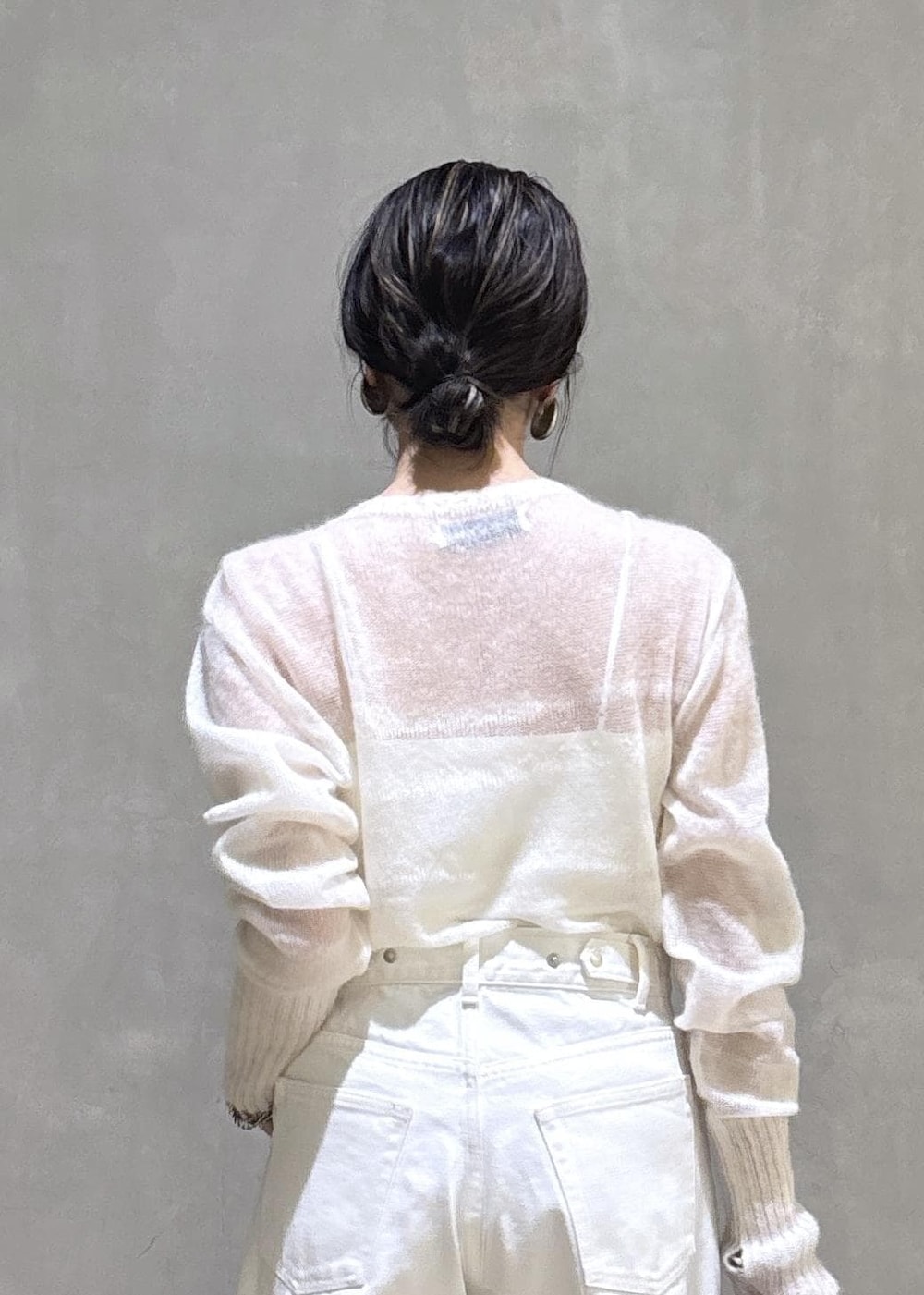 ホワイト系のパンプス、シルバー系のトートバッグ、ホワイト系のデニムパンツを着用したレディースの冬コーディネートの8枚目の写真