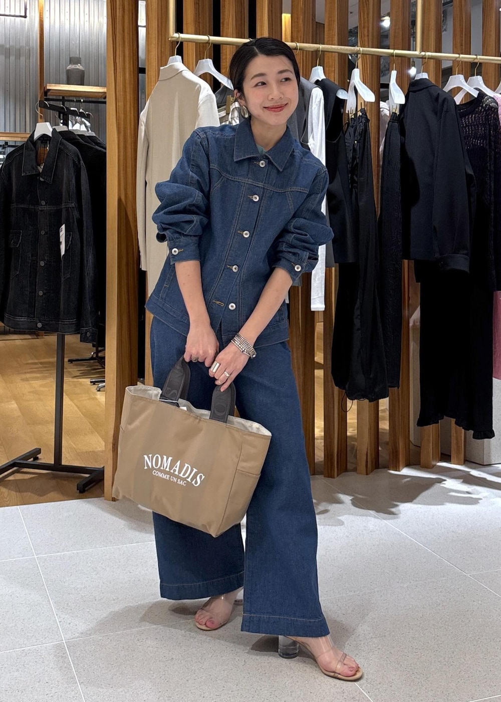 ベージュ系のハンドバッグ、ブルー系のTシャツ/カットソー、ブルー系のブルゾンを着用したレディースの冬コーディネートの3枚目の写真