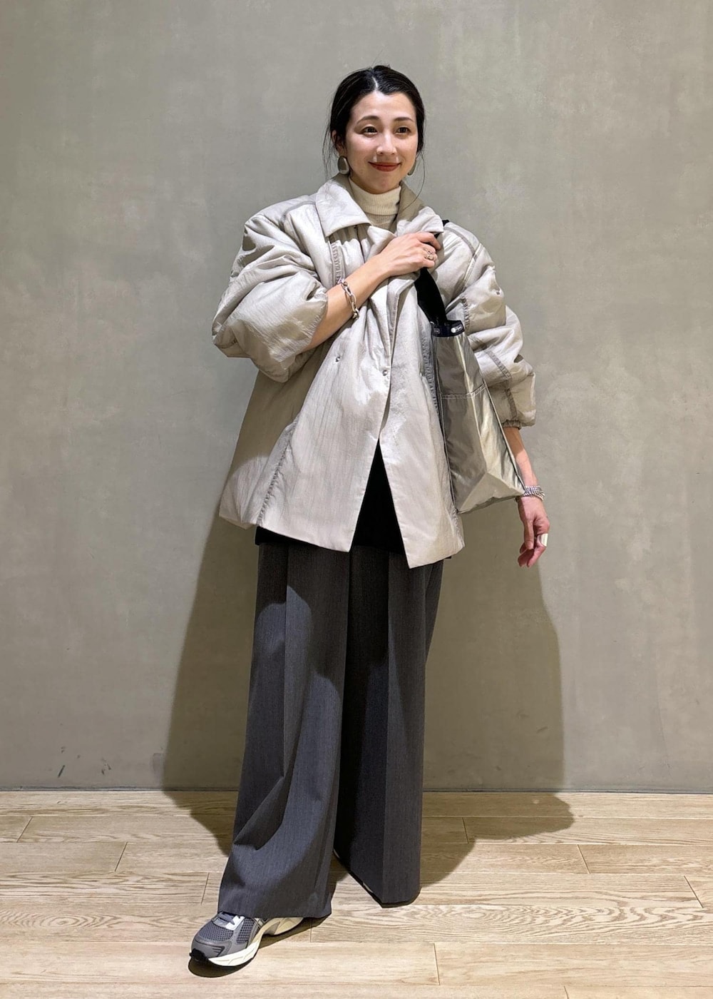 グレー系のスニーカー、ブラック系のシャツ/ブラウス、ベージュ系のブルゾンを着用したレディースの秋コーディネートの2枚目の写真