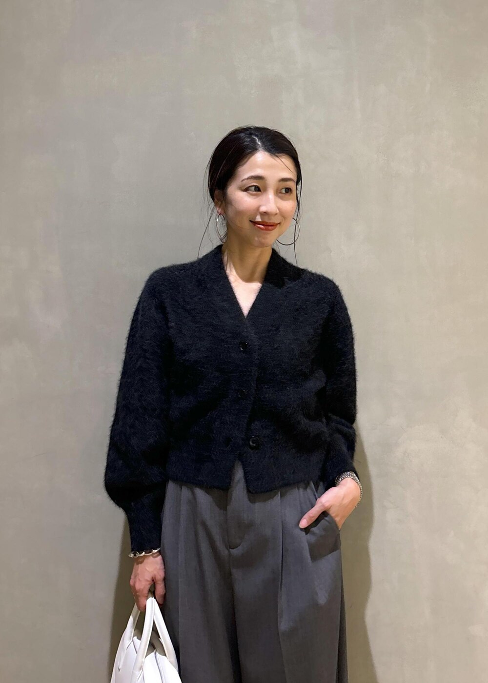 ホワイト系のボストンバッグ、グレー系のカーディガン/ボレロ、ブルー系のスニーカーを着用したレディースの秋コーディネートの8枚目の写真