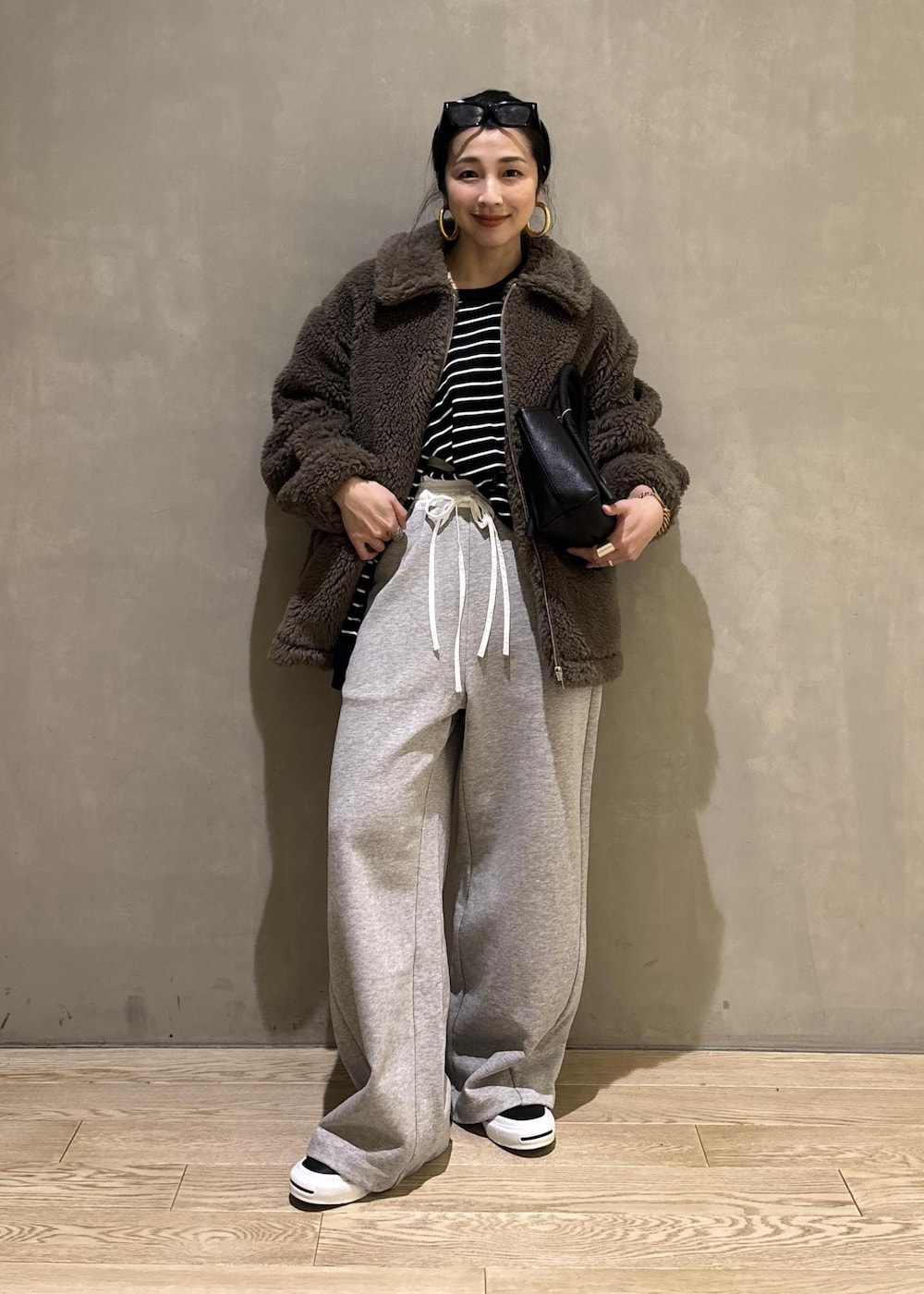 グリーン系のブルゾン、グレー系のその他パンツを着用したレディースの冬コーディネートの2枚目の写真