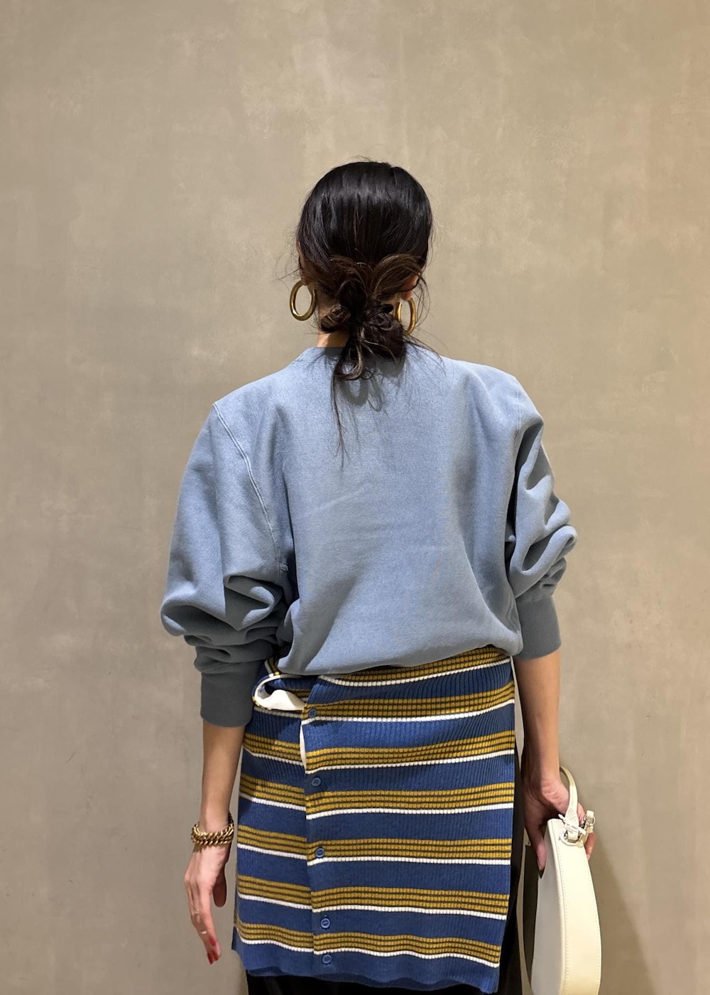 ホワイト系のハンドバッグ、ブルー系のスウェット、ブルー系のポロシャツを着用したレディースの秋コーディネートの8枚目の写真