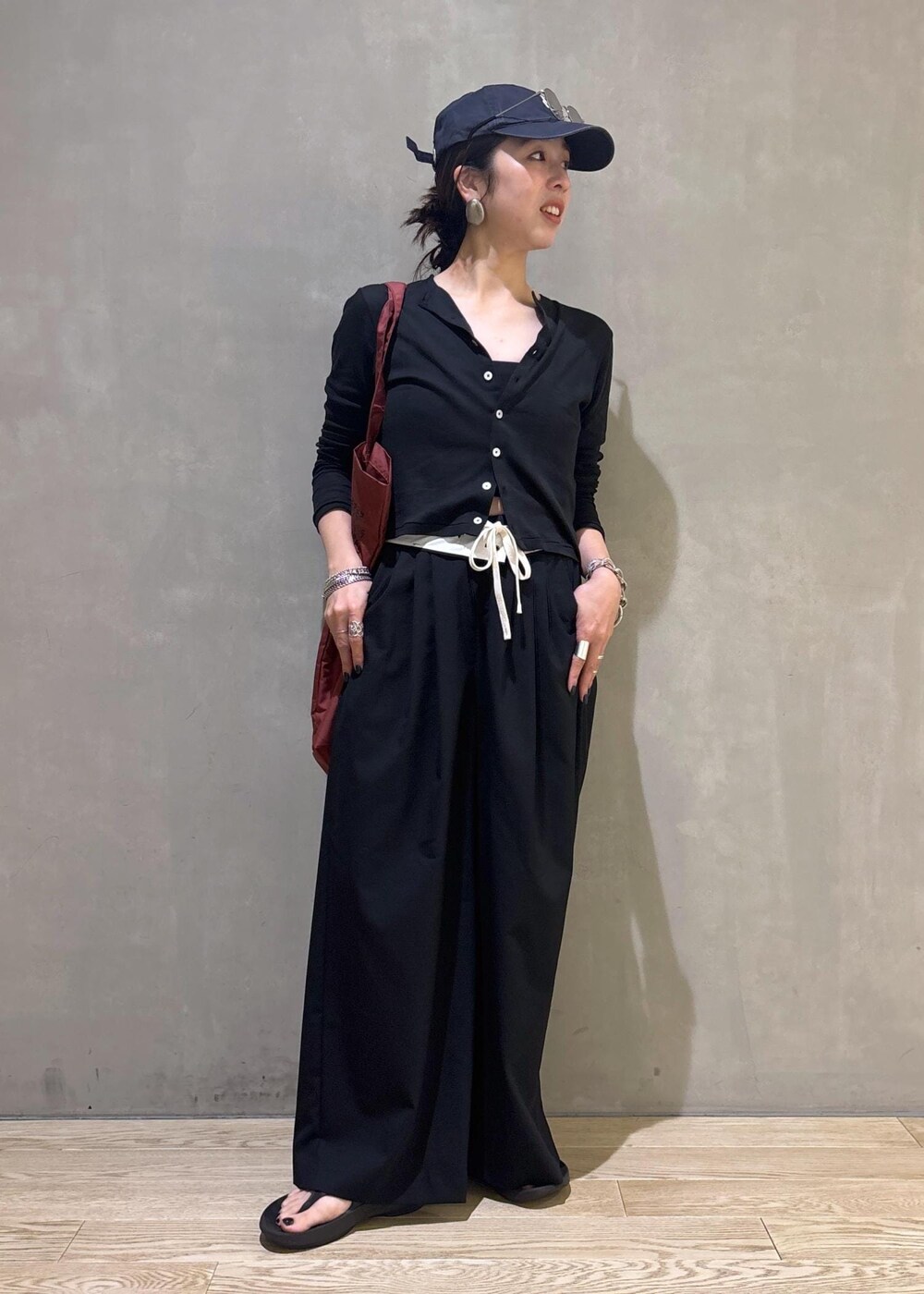 ブラック系のカーディガン/ボレロ、ブラック系のスラックス、シルバー系のサングラスを着用したレディースの夏コーディネートの4枚目の写真