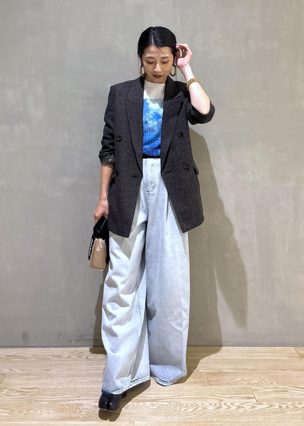 ベージュ系のトートバッグ、ホワイト系のTシャツ/カットソー、ブルー系のその他パンツを着用したレディースの秋コーディネートの3枚目の写真