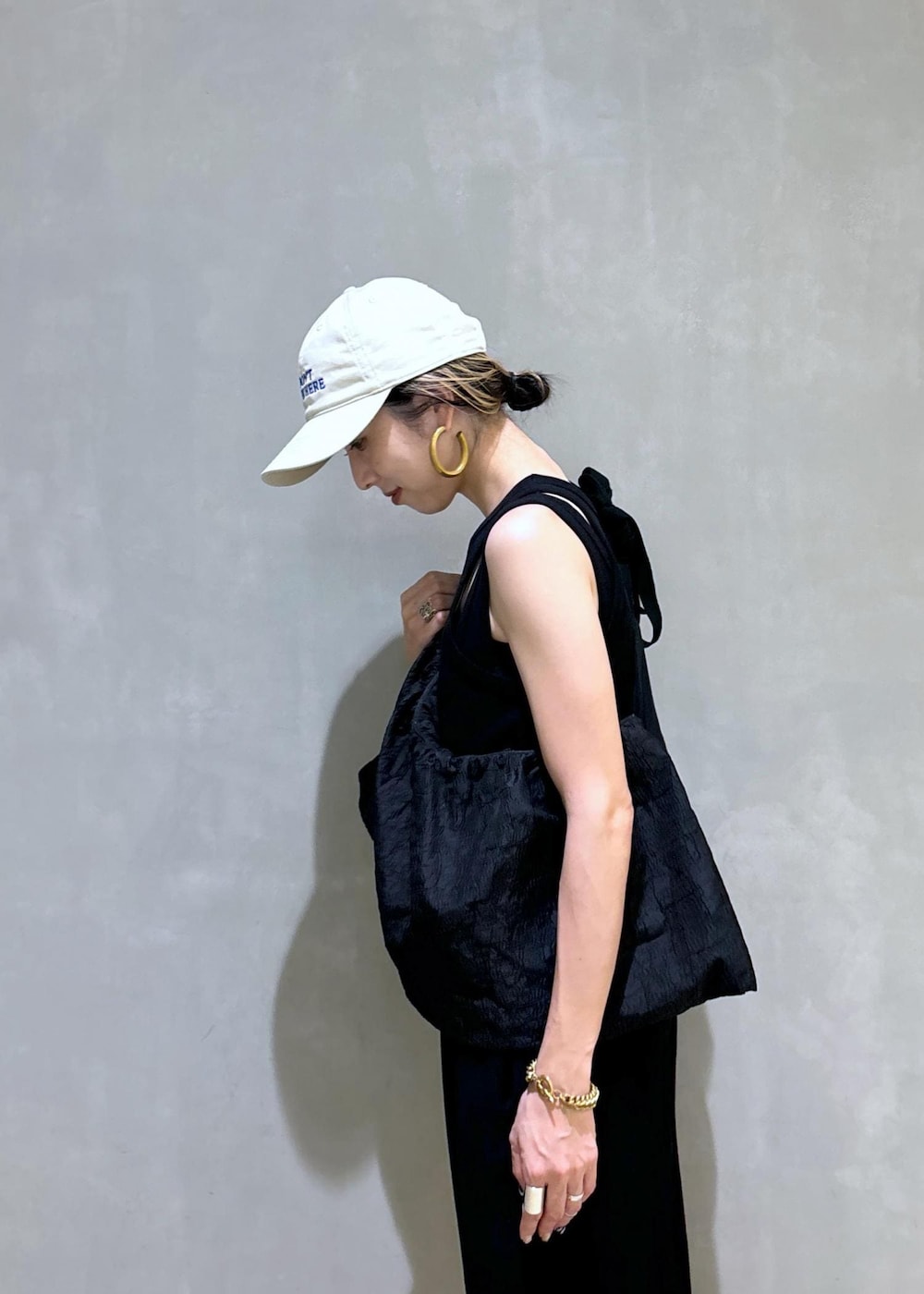 ブラック系のスニーカー、ブラック系のつなぎ/オールインワン、ベージュ系のキャップを着用したレディースの夏コーディネートの8枚目の写真