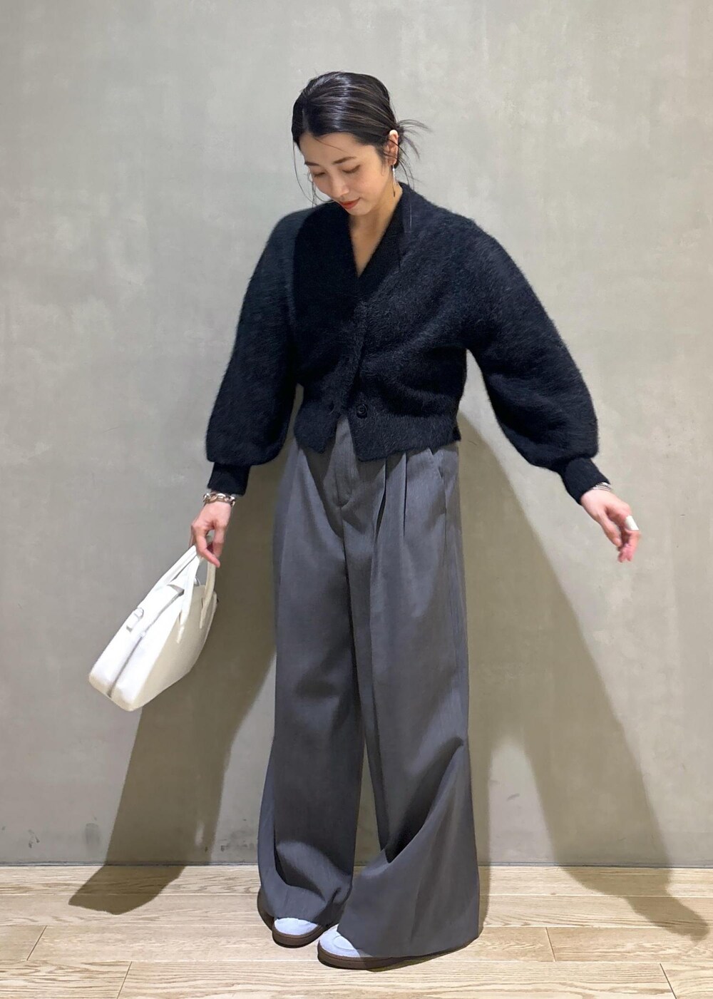 ホワイト系のボストンバッグ、グレー系のカーディガン/ボレロ、ブルー系のスニーカーを着用したレディースの秋コーディネートの6枚目の写真