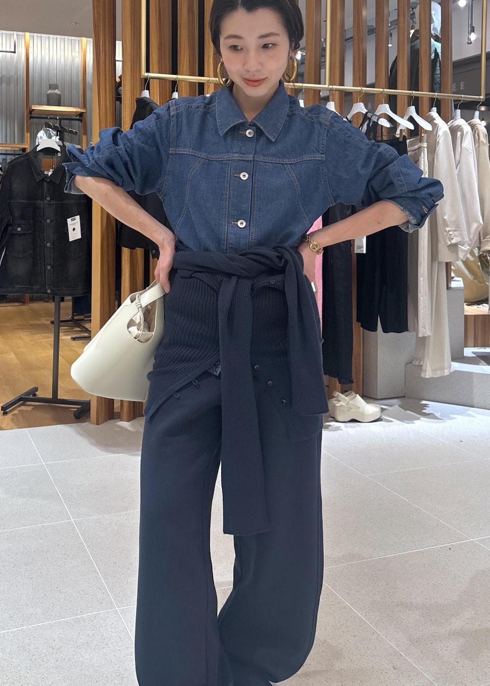 ブラック系のローファー、ホワイト系のハンドバッグ、ブルー系のブルゾンを着用したレディースの春コーディネートの7枚目の写真