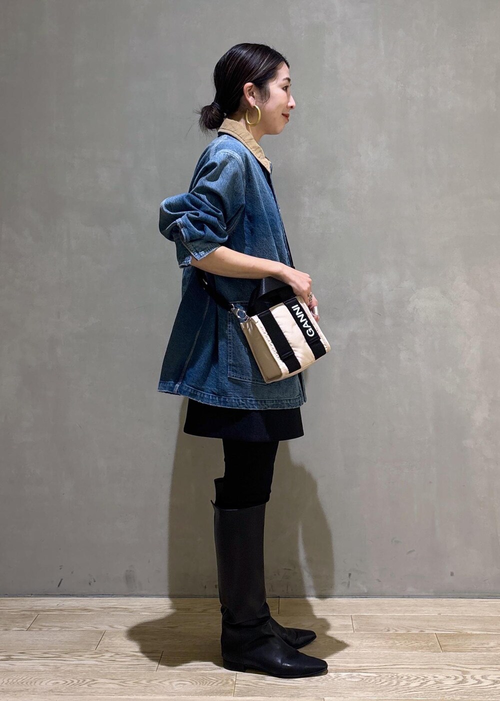 ベージュ系のトートバッグ、ブラック系のブーツ、ブラック系のスカートを着用したレディースの冬コーディネートの10枚目の写真