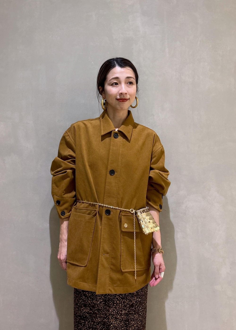 ブラック系のブーツ、ブラック系のスカート、イエロー系のブルゾンを着用したレディースの冬コーディネートの6枚目の写真