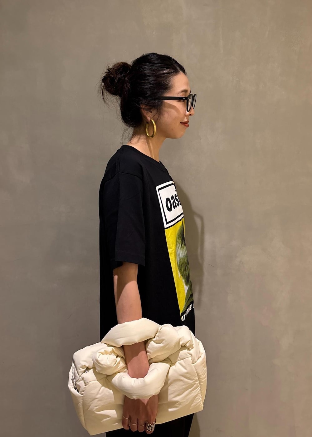 ブラック系のスラックス、イエロー系のTシャツ/カットソーを着用したレディースの夏コーディネートの7枚目の写真