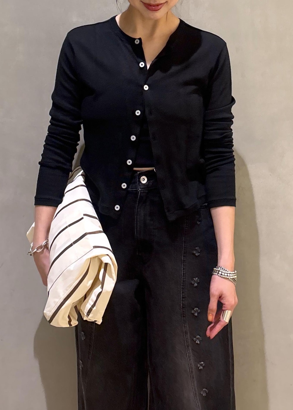 ブラック系のカーディガン/ボレロ、ホワイト系のショルダーバッグ、ブラック系のデニムパンツを着用したレディースの春コーディネートの10枚目の写真