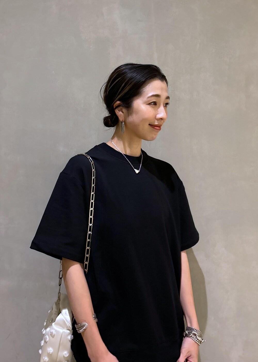 ホワイト系のショルダーバッグ、ブラック系のブーツ、ブラック系のワンピースを着用したレディースの夏コーディネートの9枚目の写真