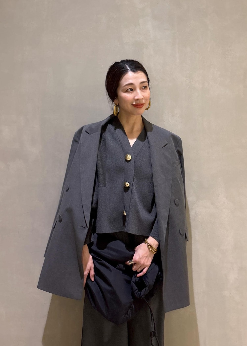ブラック系のトートバッグ、グレー系のテーラードジャケット、グレー系のその他パンツを着用したレディースの冬コーディネートの9枚目の写真