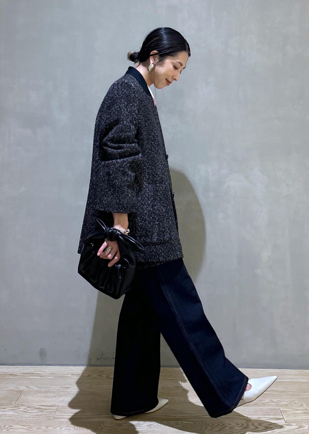 ブラック系のショルダーバッグ、ホワイト系のパンプス、ブルー系のデニムパンツを着用したレディースの夏コーディネートの3枚目の写真