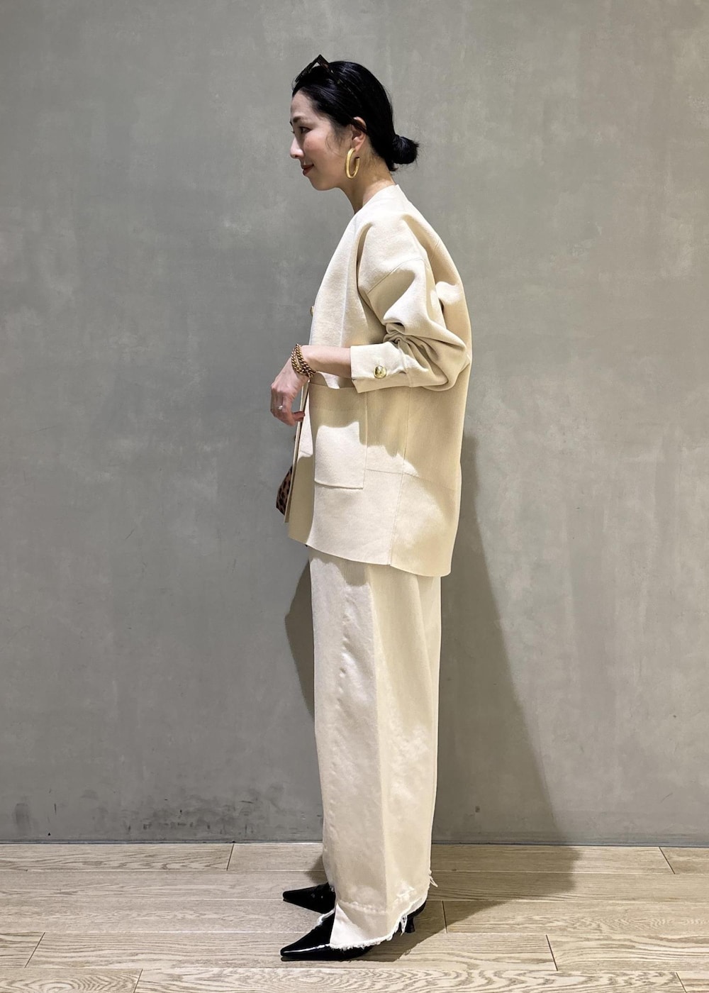 ブラック系のサンダル、ホワイト系のデニムパンツ、ホワイト系のカーディガン/ボレロを着用したレディースの冬コーディネートの7枚目の写真