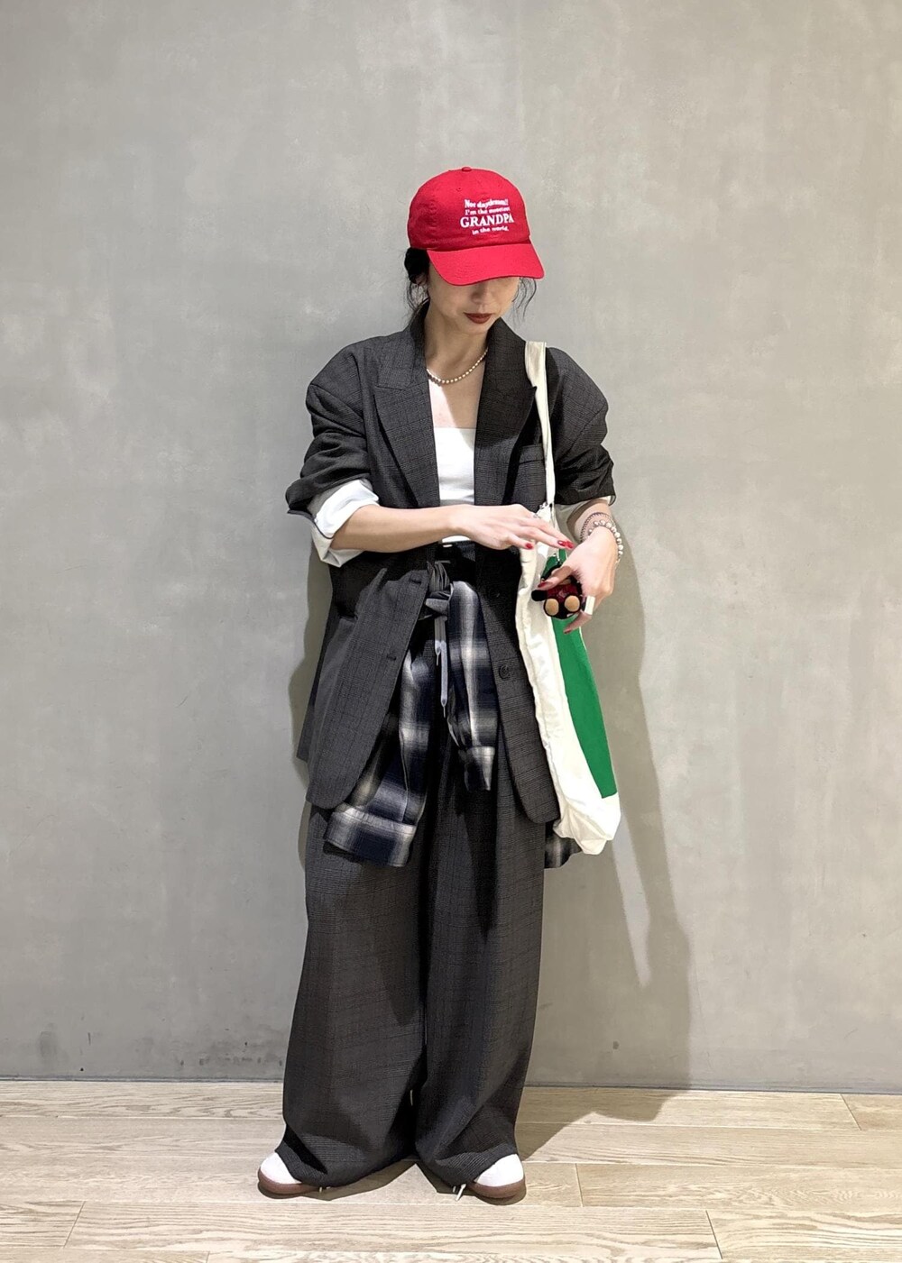 ブラック系のシャツ/ブラウス、グリーン系のトートバッグ、ブラック系のキャップを着用したレディースの秋コーディネートの5枚目の写真