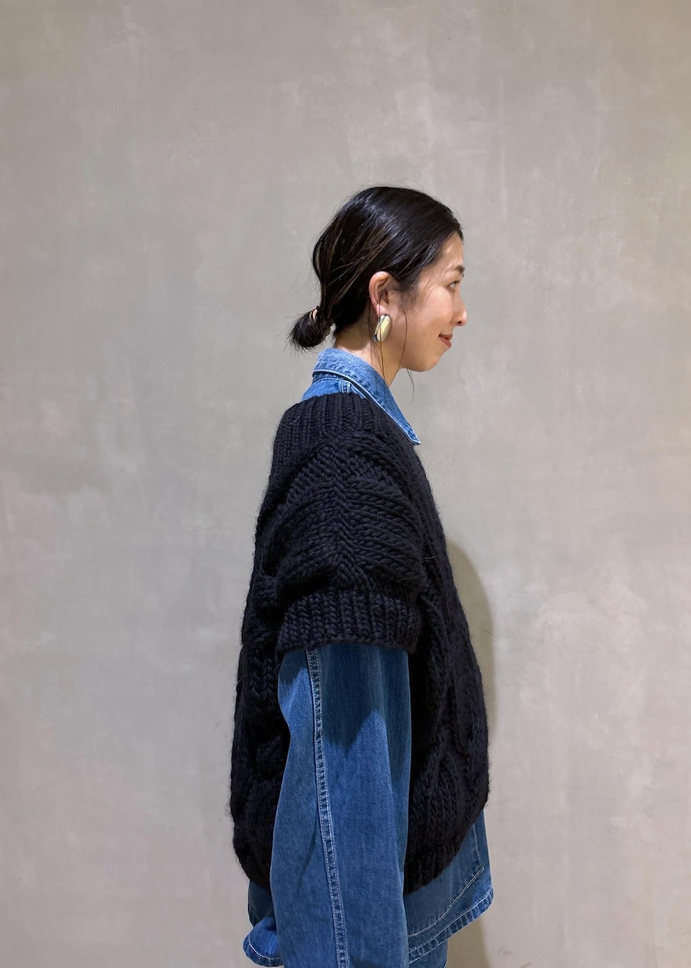 パープル系のハンドバッグ、ブルー系のカバーオール、ブルー系のデニムパンツを着用したレディースの夏コーディネートの7枚目の写真