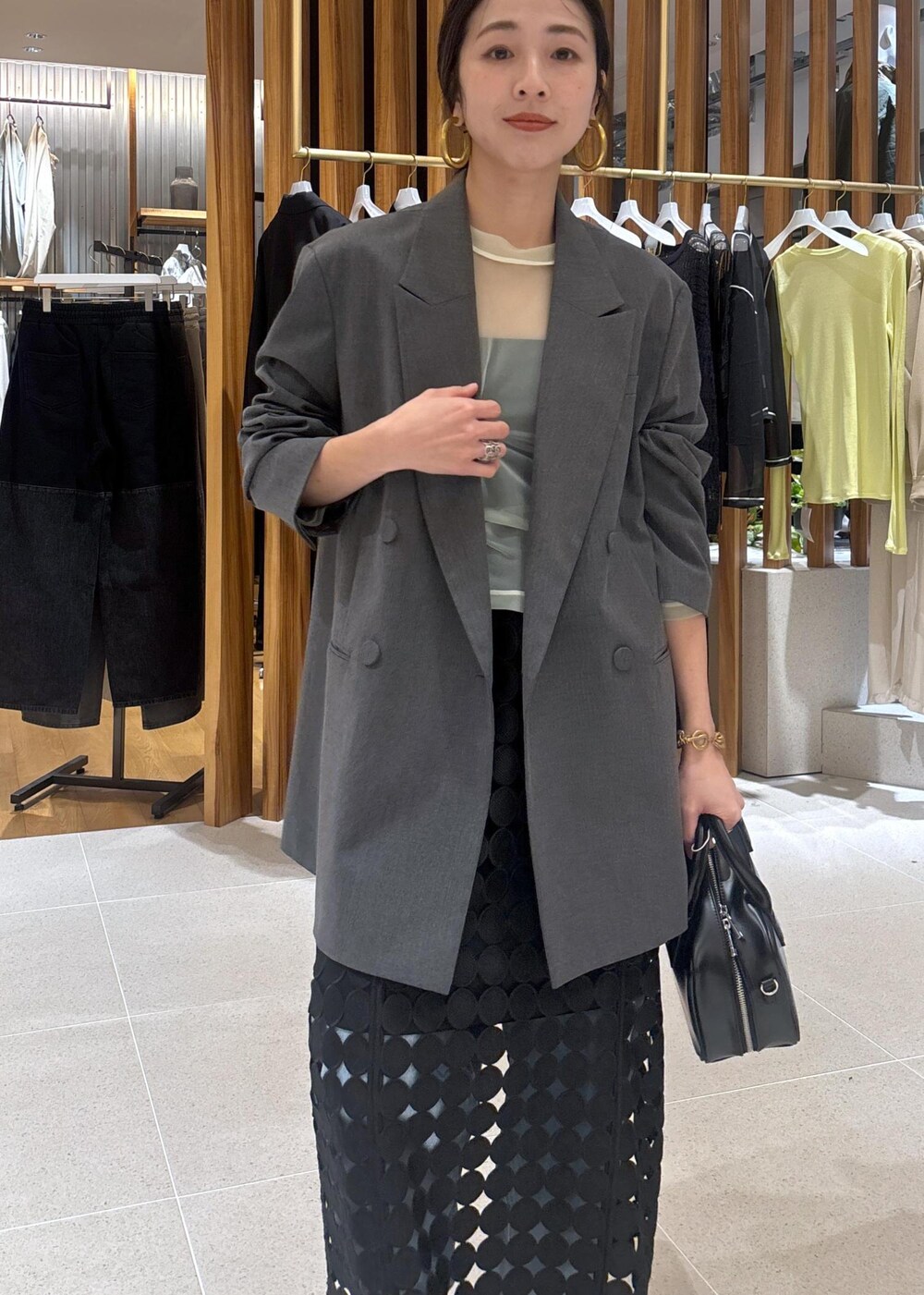 ブルー系のデニムパンツ、グレー系のテーラードジャケット、ブラック系のローファーを着用したレディースの春コーディネートの9枚目の写真