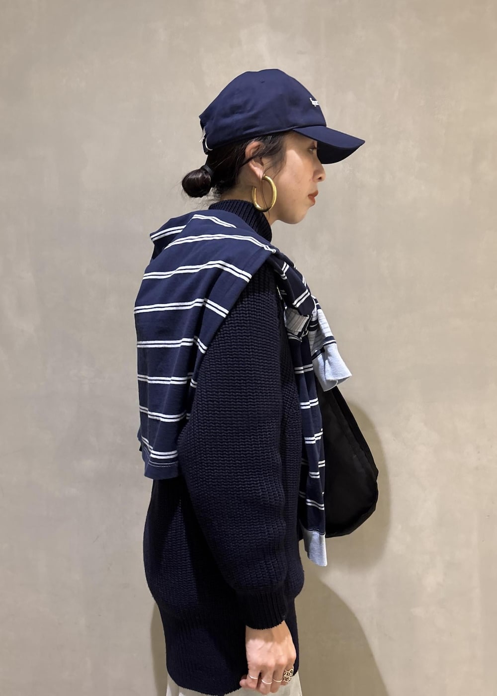 ブルー系のデニムパンツ、ブラック系のショルダーバッグを着用したレディースの秋コーディネートの8枚目の写真