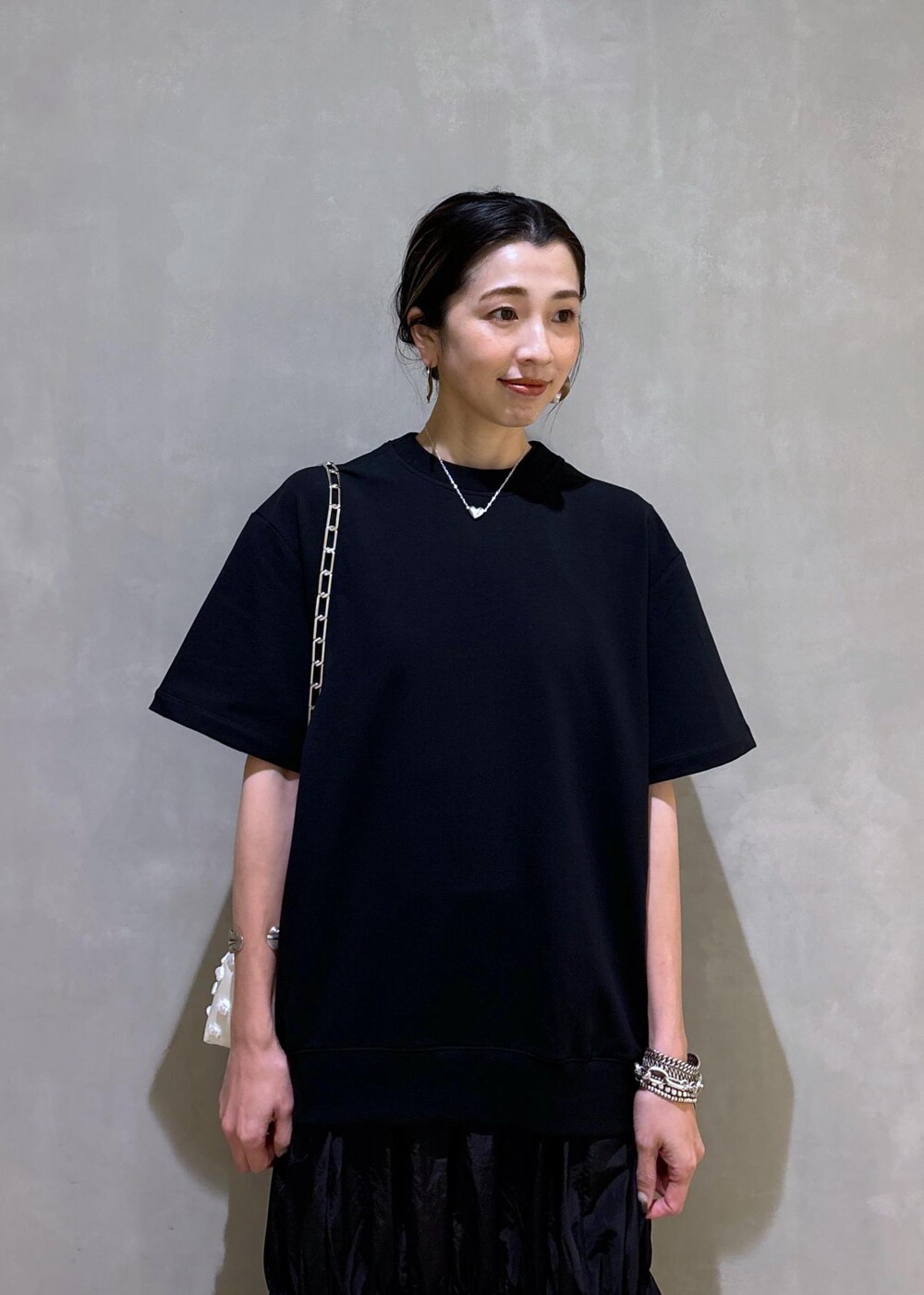 ホワイト系のショルダーバッグ、ブラック系のブーツ、ブラック系のワンピースを着用したレディースの夏コーディネートの8枚目の写真