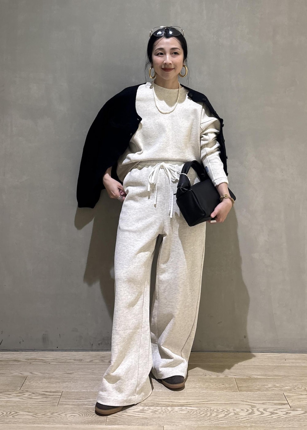 ブラック系のハンドバッグ、ホワイト系のその他パンツ、ホワイト系のスウェットを着用したレディースの冬コーディネートの3枚目の写真