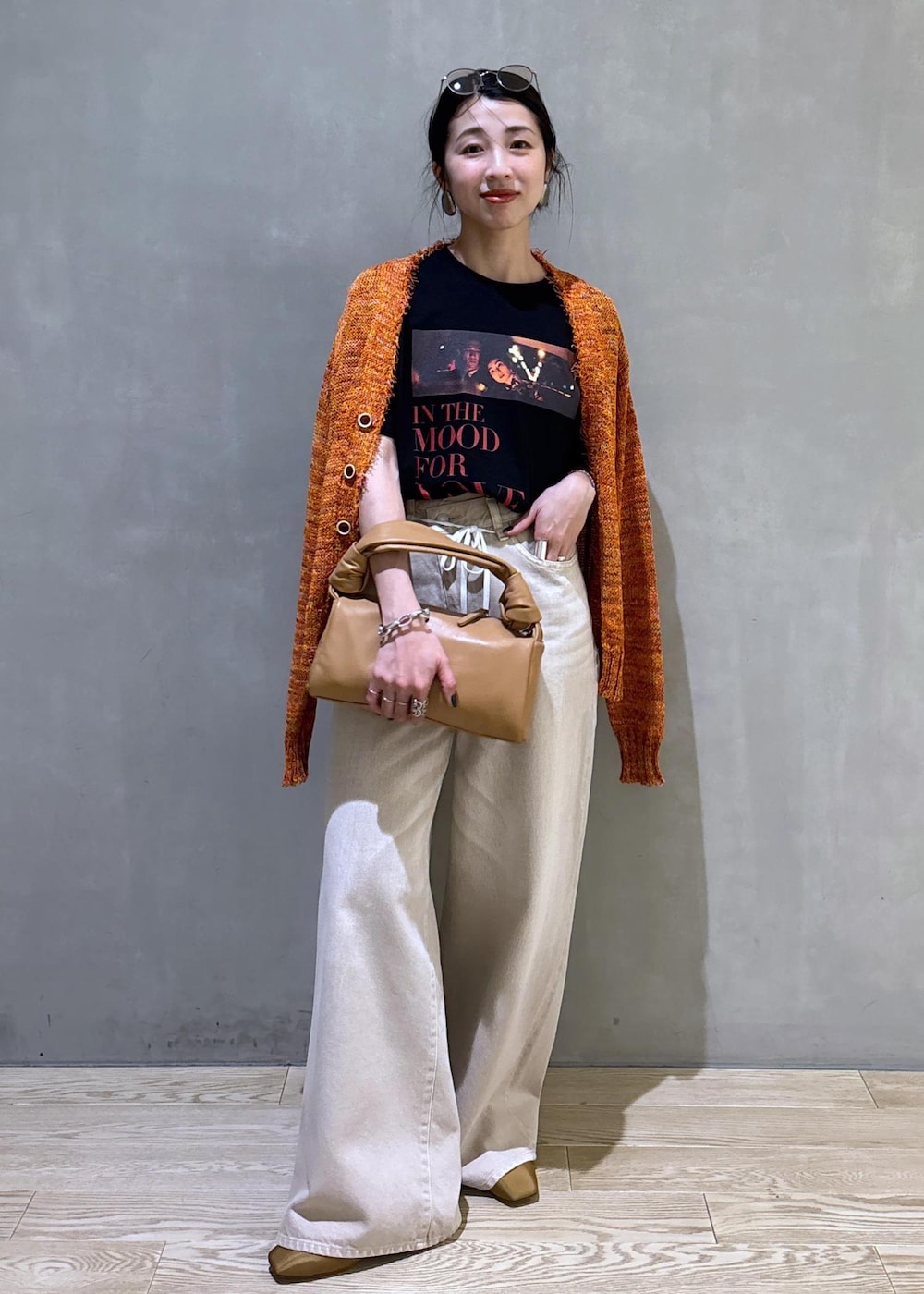 ベージュ系のハンドバッグ、ホワイト系のデニムパンツ、ホワイト系のTシャツ/カットソーを着用したレディースの春コーディネートの2枚目の写真