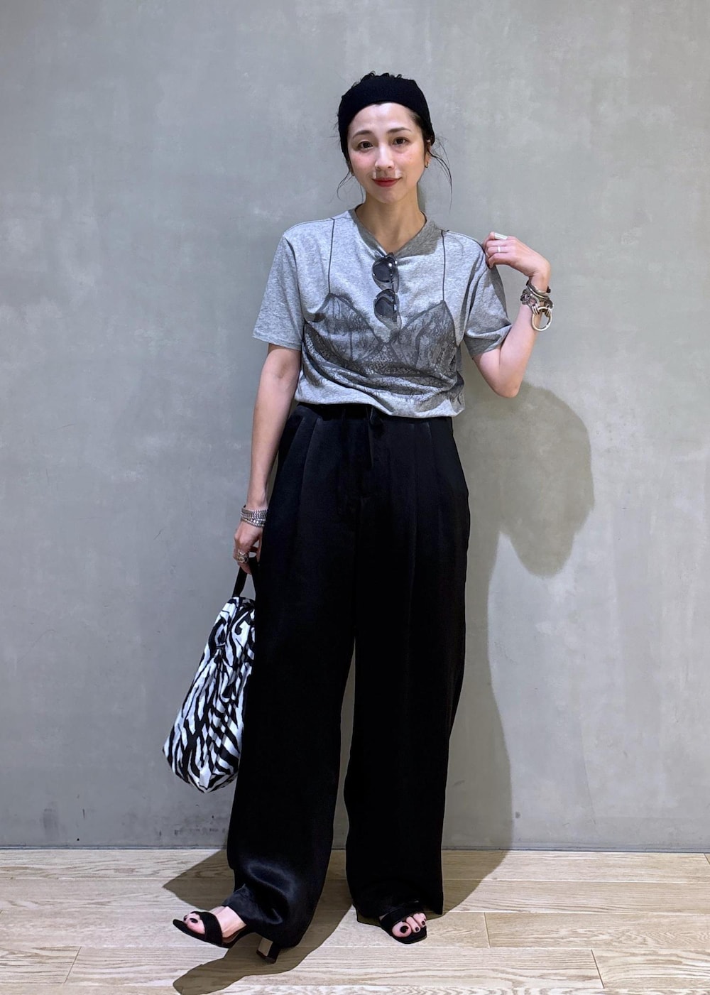 グレー系のTシャツ/カットソー、ブラック系のスラックス、ホワイト系のネックレスを着用したレディースの夏コーディネートの6枚目の写真