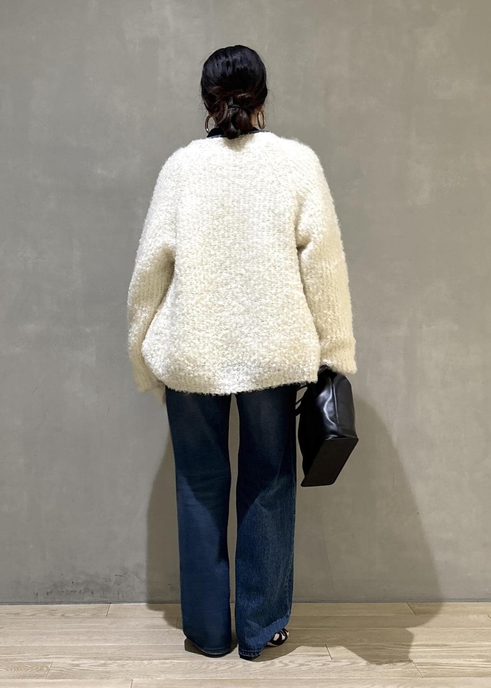 ブラック系のショルダーバッグ、ブルー系のデニムパンツ、ブルー系のカバーオールを着用したレディースの秋コーディネートの5枚目の写真