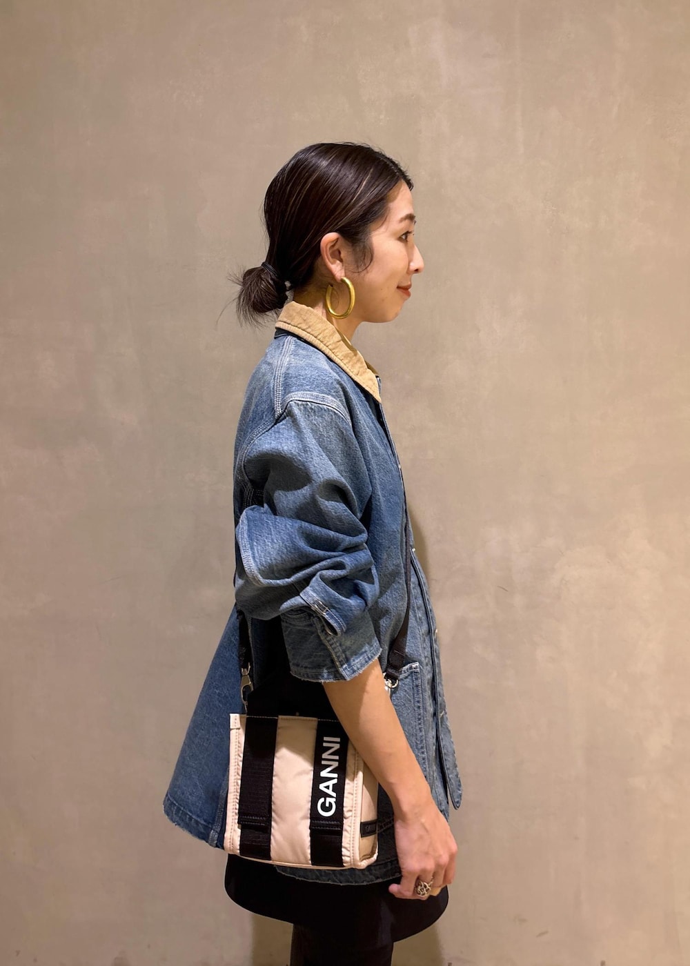 ベージュ系のトートバッグ、ブラック系のブーツ、ブラック系のスカートを着用したレディースの冬コーディネートの8枚目の写真