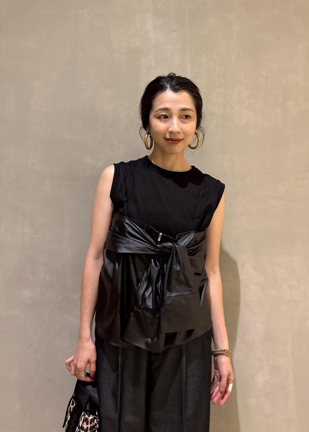 ブラック系のサンダル、ブラック系のデニムパンツ、ベージュ系のショルダーバッグを着用したレディースの夏コーディネートの7枚目の写真
