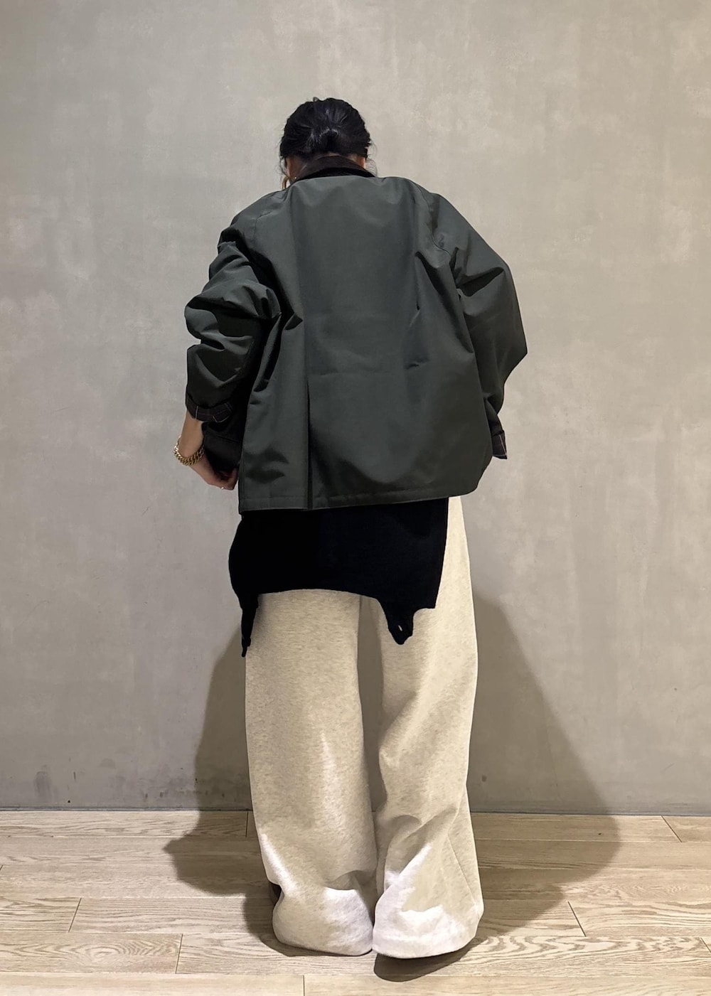 ブラック系のハンドバッグ、グリーン系のその他アウター、ホワイト系のその他パンツを着用したレディースの冬コーディネートの4枚目の写真