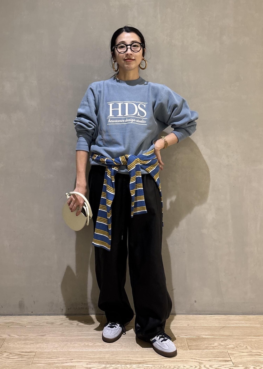 ホワイト系のハンドバッグ、ブルー系のスウェット、ブルー系のポロシャツを着用したレディースの秋コーディネートの5枚目の写真